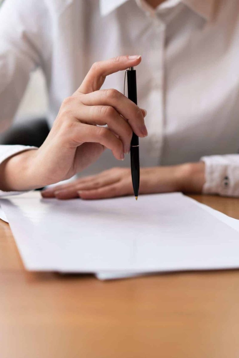 Imagen de una persona firmando una escritura en una notaría, con asesoramiento profesional.